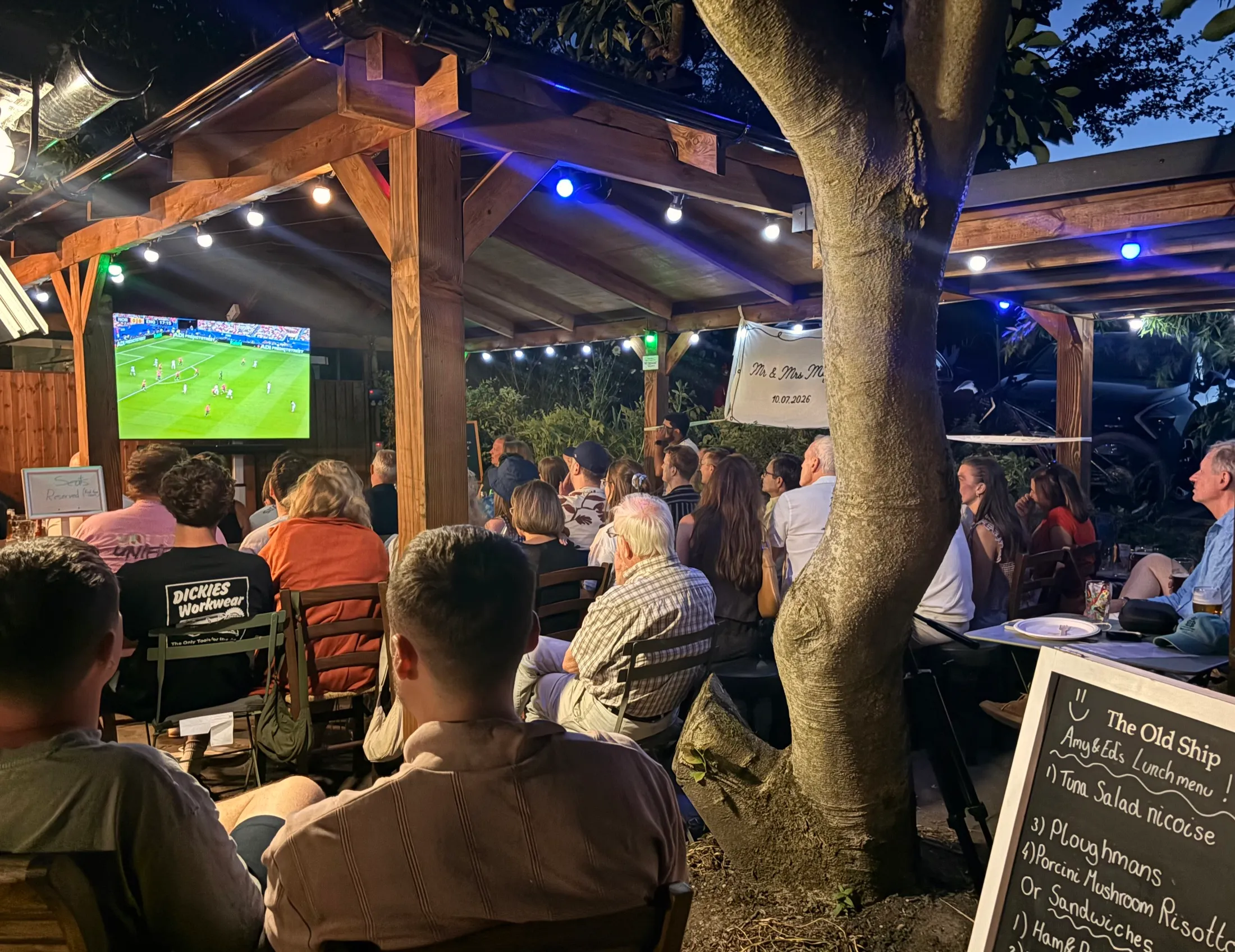 A warm evening under the pergola, a full house with festoon lights overhead
