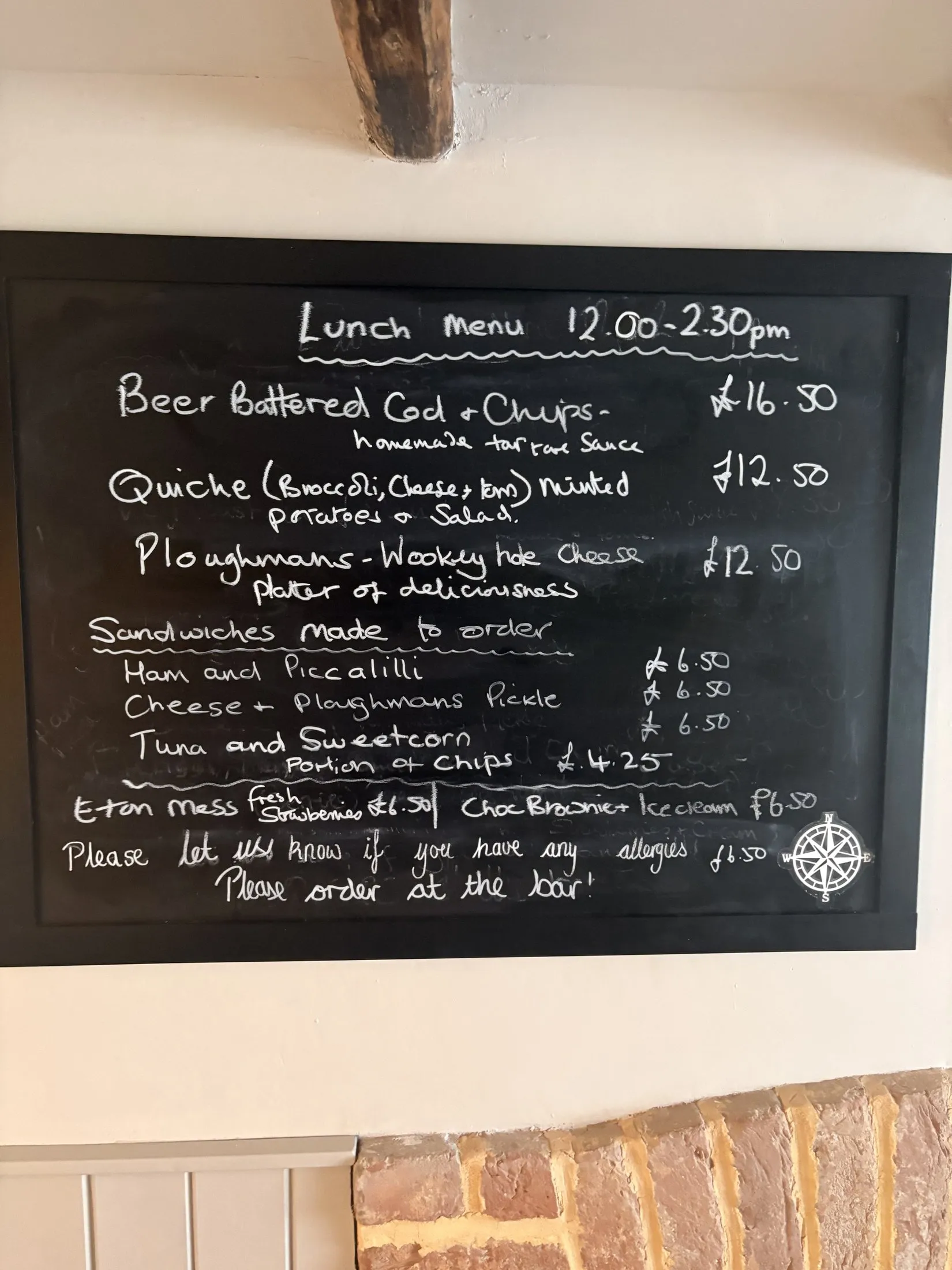 A chalkboard lunch menu with beer-battered cod and chips, quiche and ploughman's